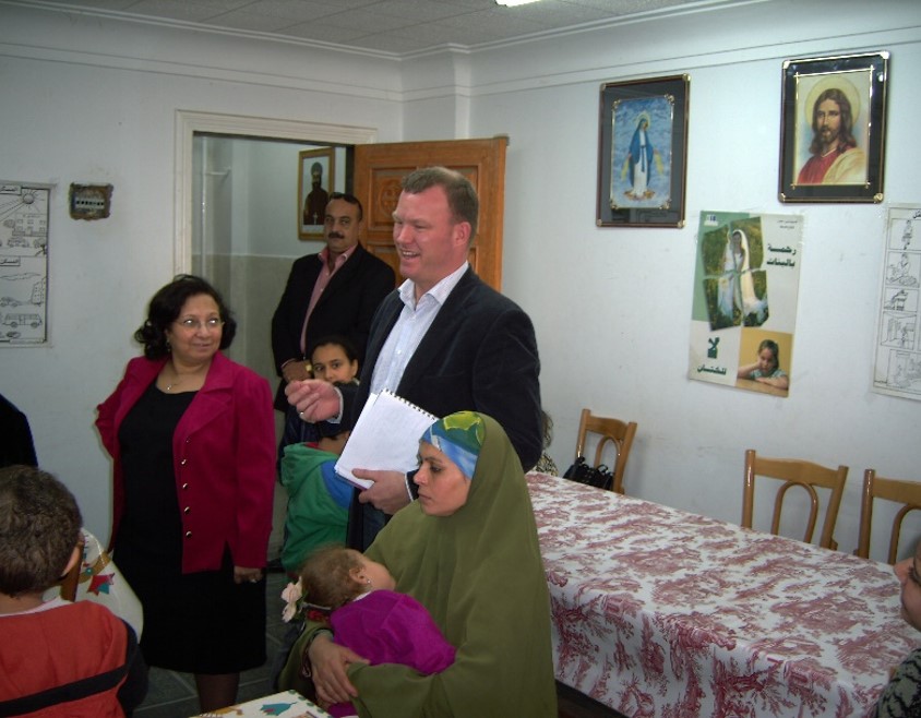 Danmissions landechef står midt i en mindre forsamling i et mindre lokale i en koptisk kirke. På væggen hænger religiøse tegninger bl.a. en af Jesus.
