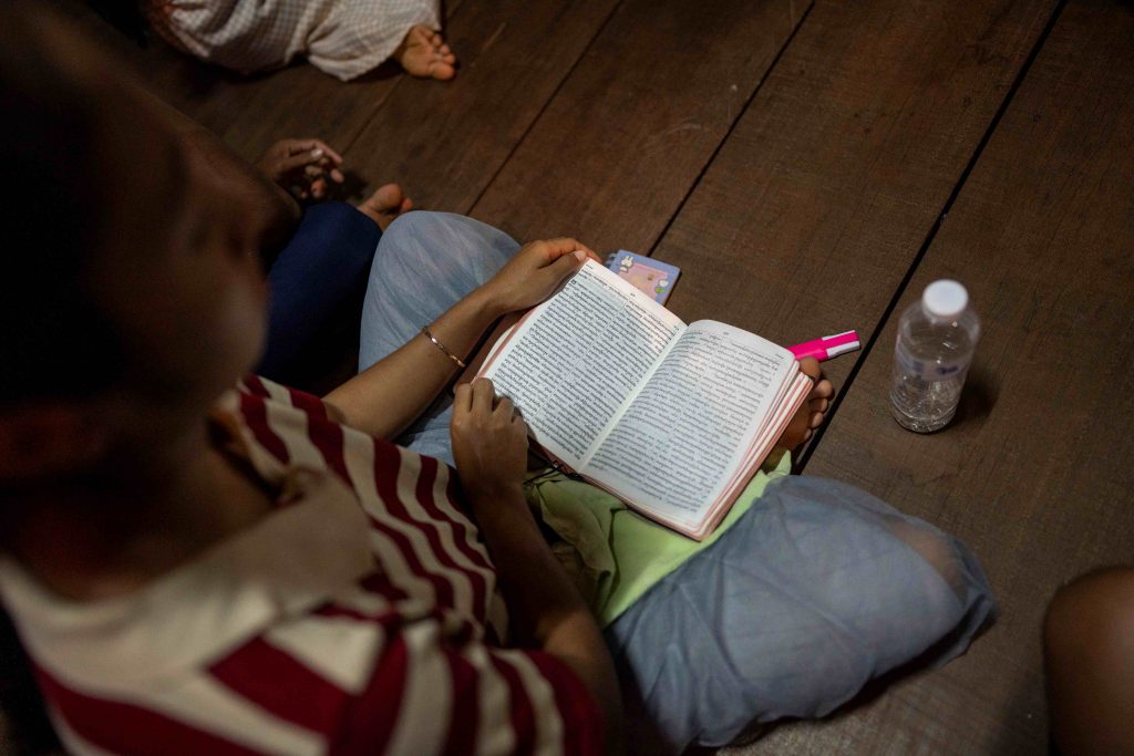 Deltager i gudstjeneste i huskirke i Cambodja læser i en bibel.