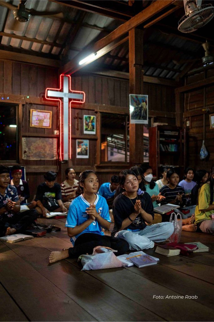 Unge kvinder sidder på gulvet under en gudstjeneste i en huskirke i Cambodja.