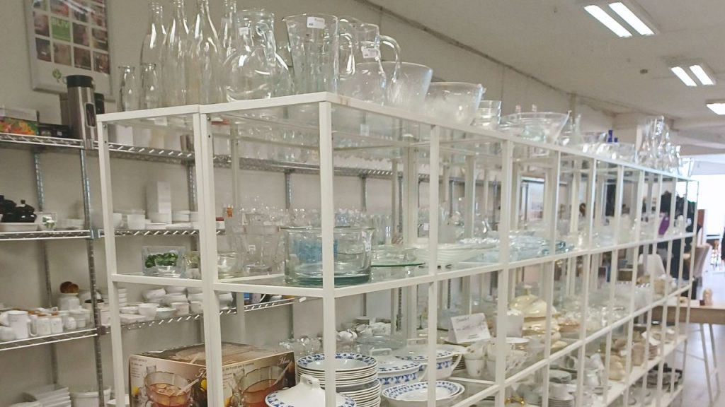 Genbrugsvarer, glas og porcelæn på reoler, i Danmissions genbrugsbutik i Haderslev