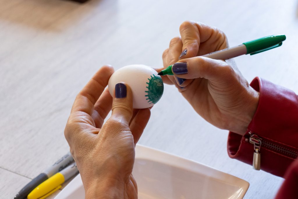 En kvinde maler med tusch på et æg.