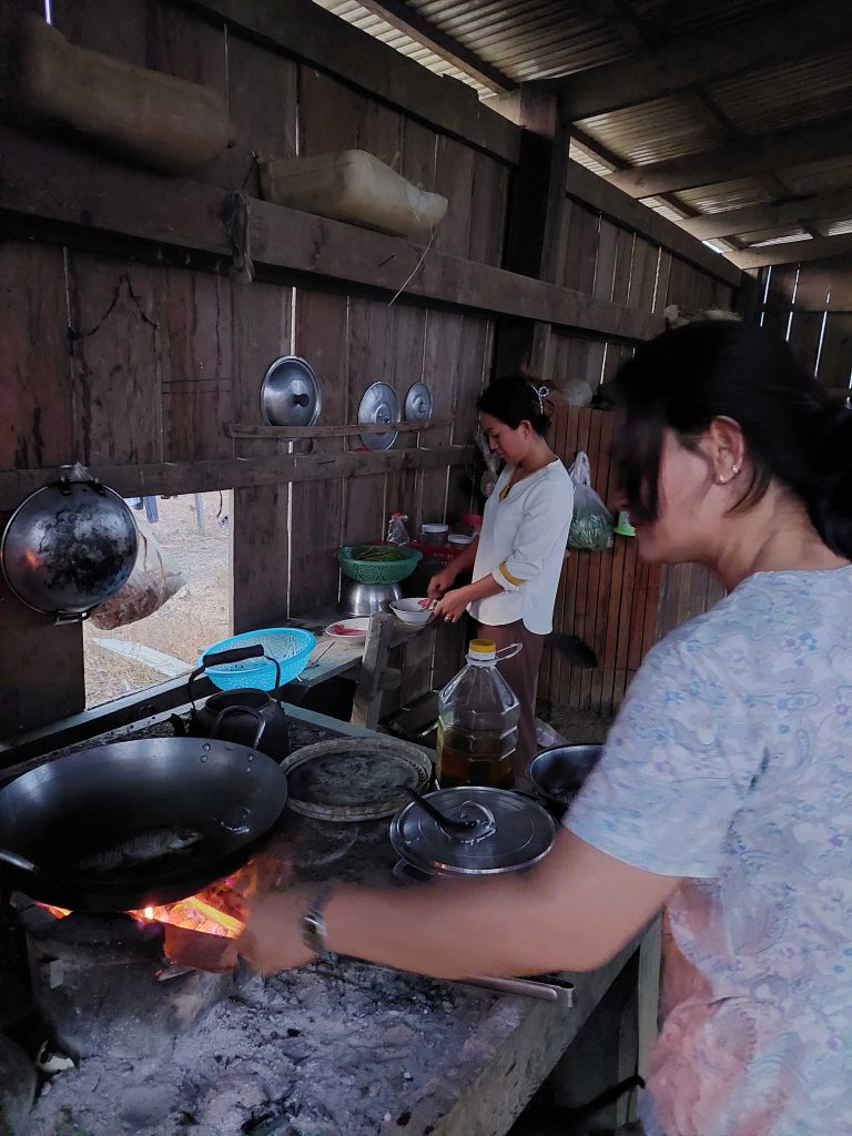To kvinder arbejder i et primitivt køkken.